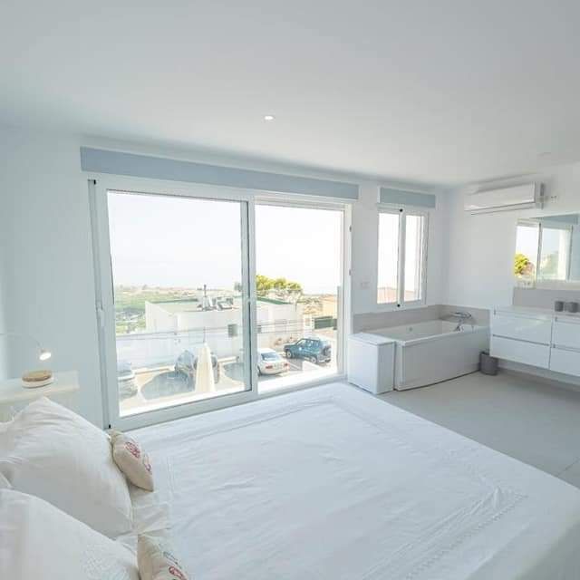 Promoycon Millán E Hijo elegante habitacion con cama y baño con bañera al fondo